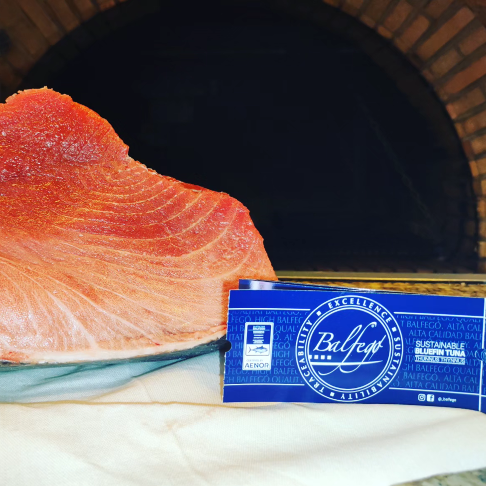 Un trozo de carne está en un plato junto a una tarjeta de Baleys.