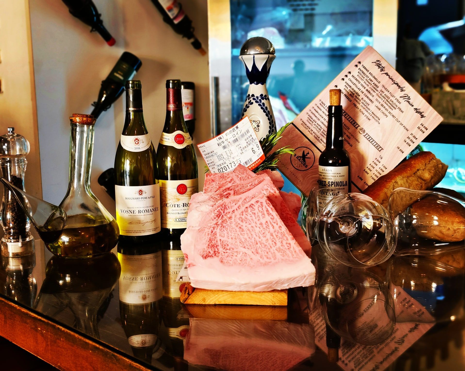 Una mesa con botellas de vino y un menú encima.