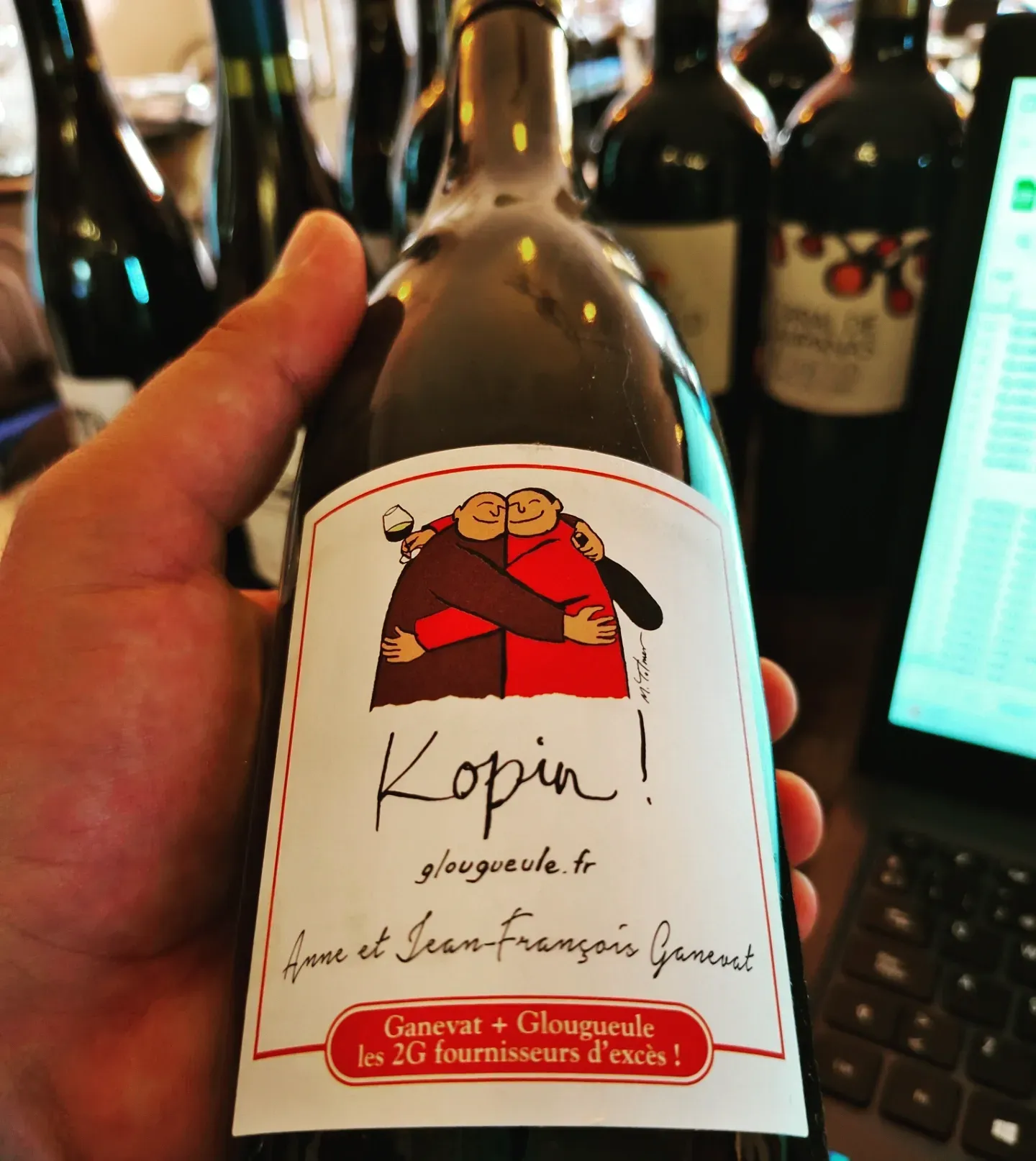 Una persona sostiene una botella de vino Kopin.