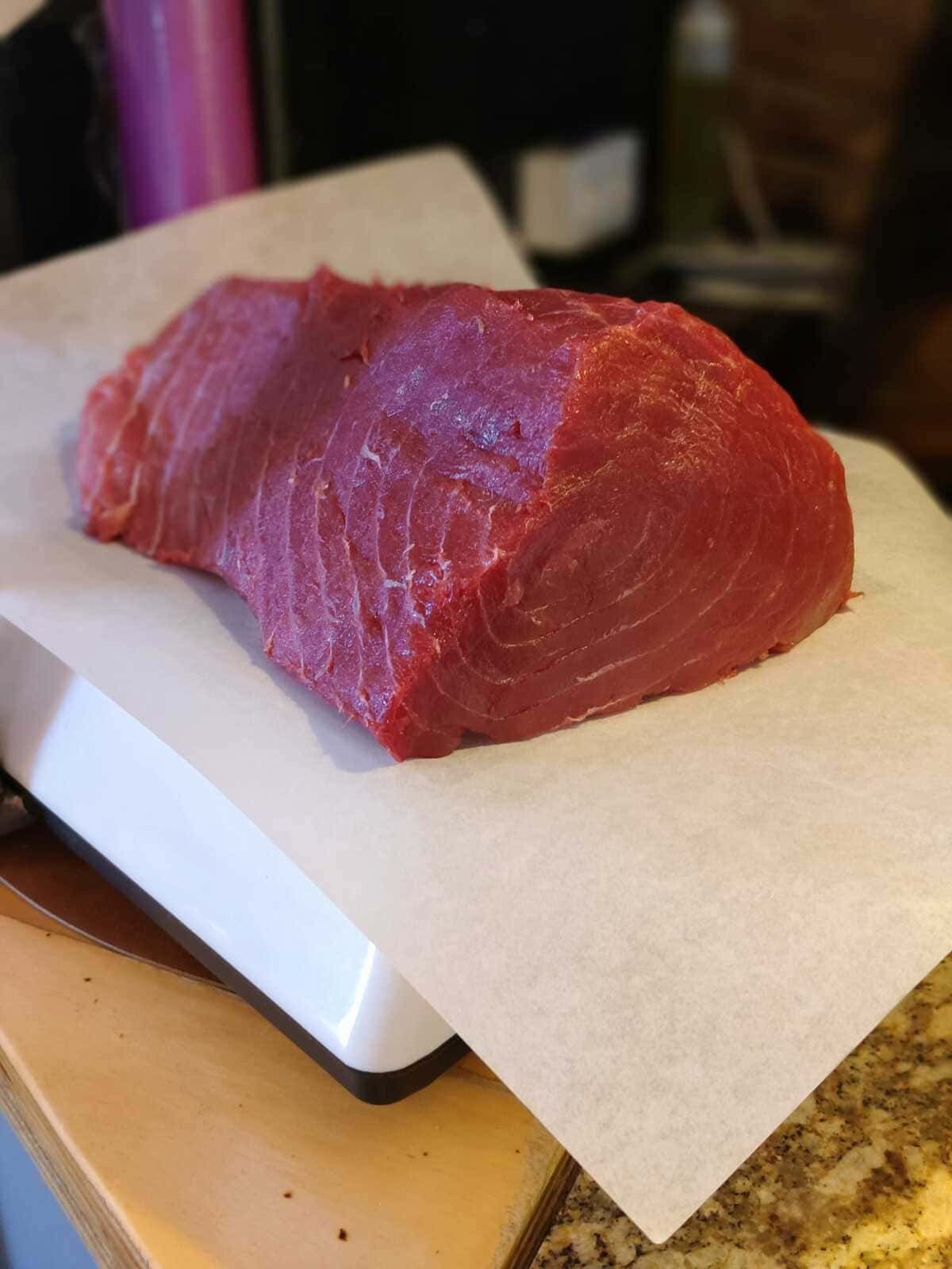 Carne roja cruda sobre papel pergamino en una báscula de cocina