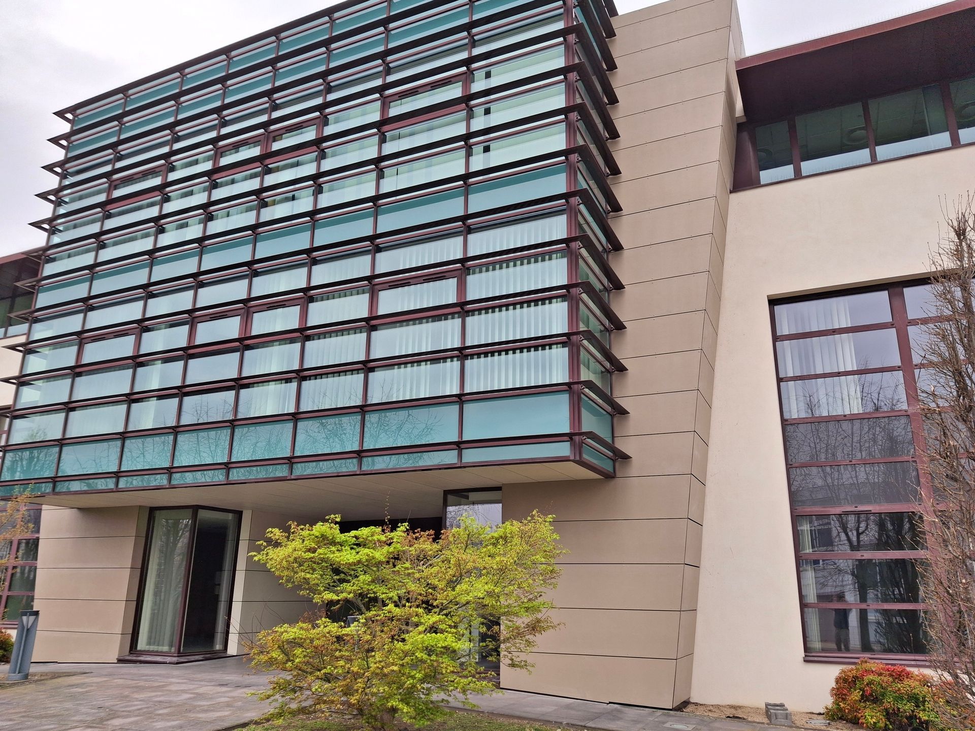 Bâtiment moderne avec une façade en verre, des finitions marron.