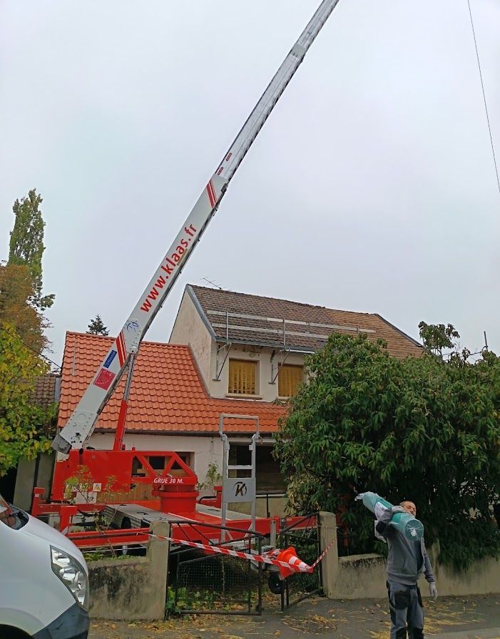Grue rouge contre une maison.