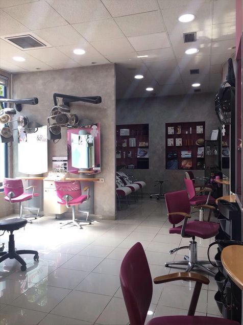 Una peluquería con muchas sillas y espejos.