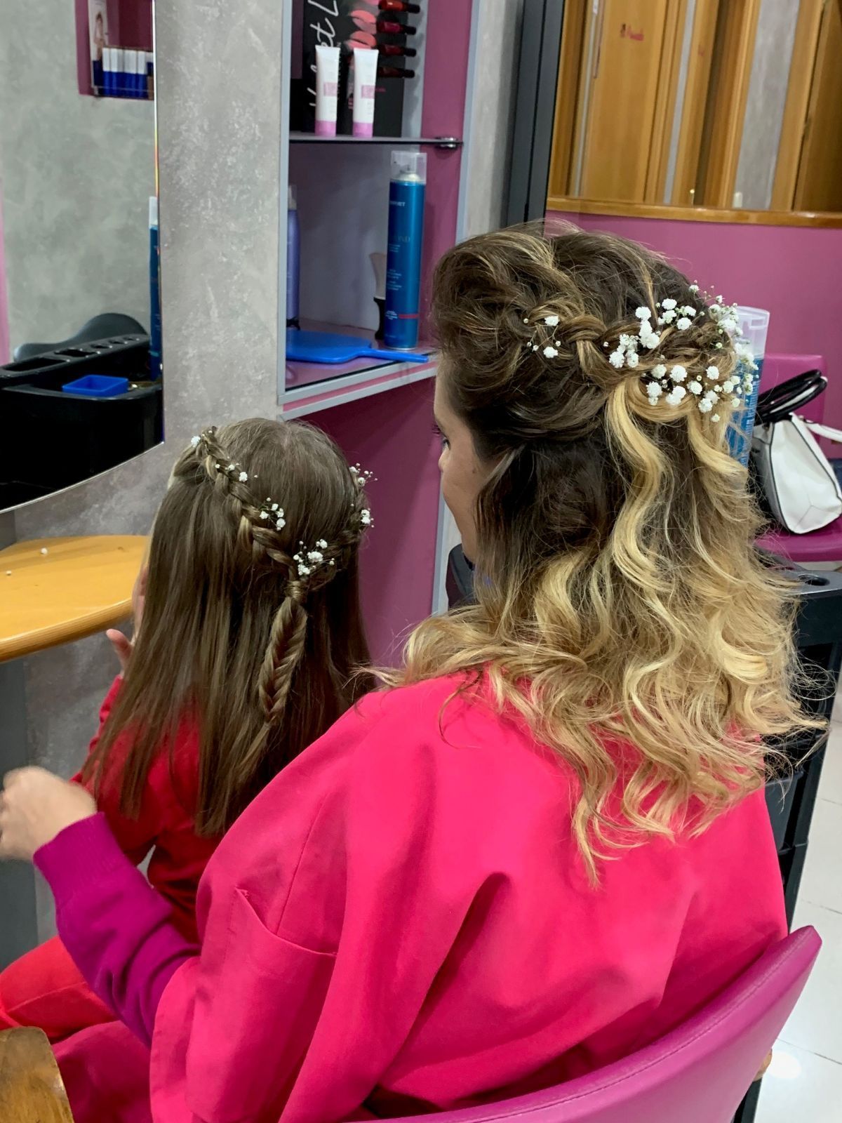 Una mujer y una niña se están peinando en una peluquería.