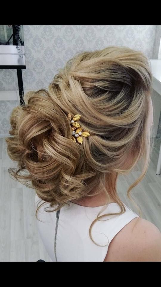 Una mujer lleva el pelo recogido en un moño con una flor en el pelo.