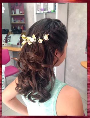 Una mujer lleva el cabello recogido mitad arriba y mitad abajo con flores.