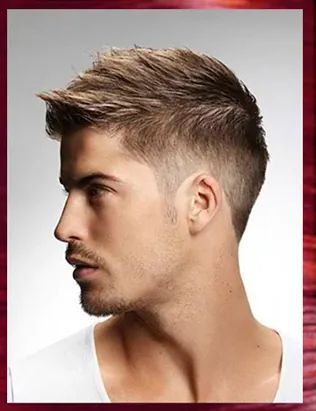Un hombre con barba y pelo corto lleva una camisa blanca.