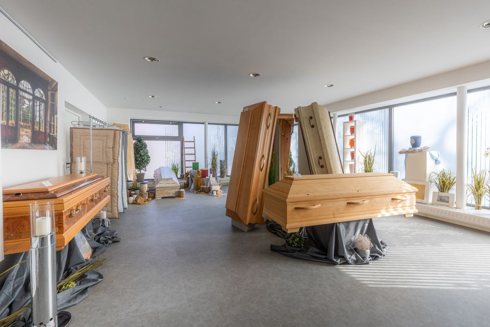 Drei gerahmte Drucke an einer weißen Wand neben einem dunklen Regal mit einer Laterne und kleinen Kunstwerken.