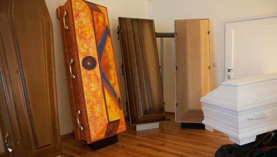 In einem Zimmer mit Holzboden stehen mehrere Matratzen und Holzbetten/Matratzen aufrecht.