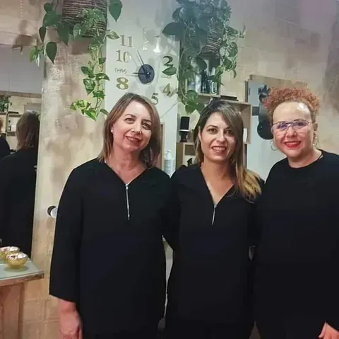Tres mujeres posan para una fotografía frente a un reloj.