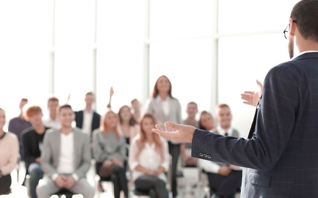 Un hombre está dando una presentación a un grupo de personas sentadas en sillas.