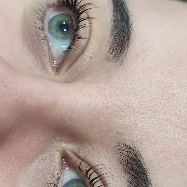 Primer plano de dos ojos verdes con pestañas largas y oscuras y cejas bien cuidadas sobre piel pálida.