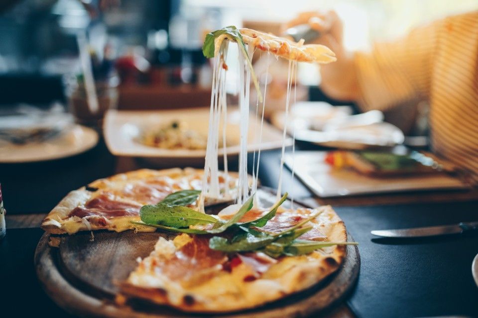 Menschen sitzen im Restaurant und essen Pizza