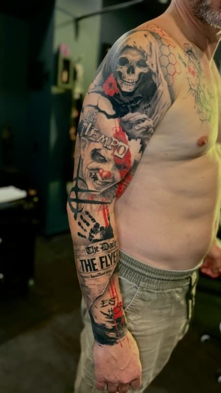 Torso y brazo de una persona que muestra un colorido tatuaje con diseños de calaveras y payasos.