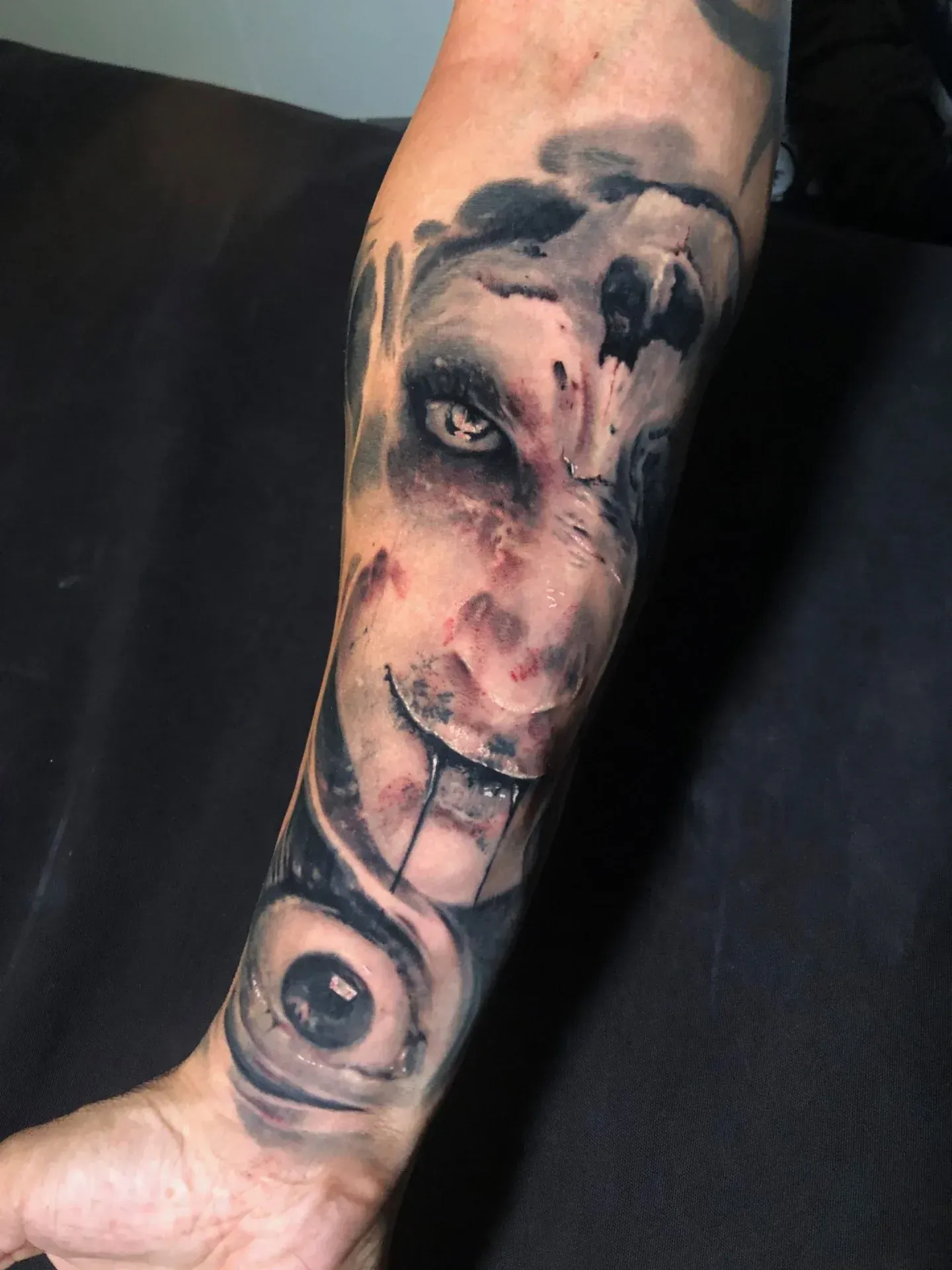 Tatuaje con temática de terror en el antebrazo, que presenta una cara parecida a la de un zombie.