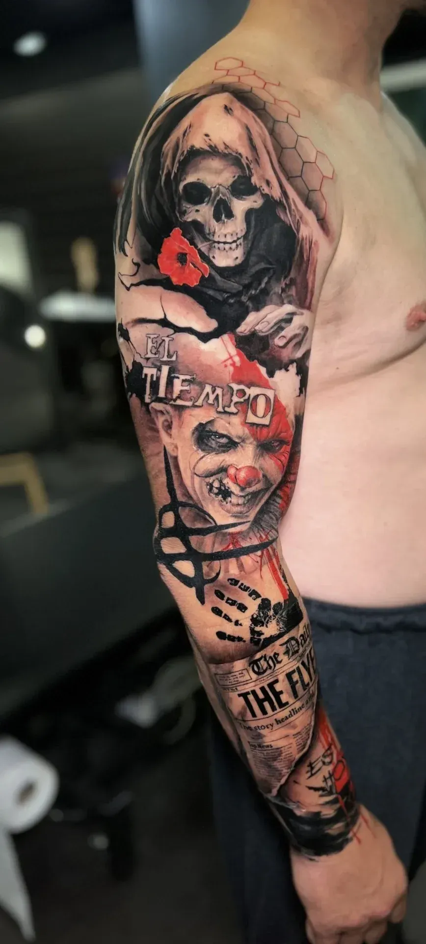Manga de tatuaje que presenta una calavera, un payaso y una lápida con las palabras