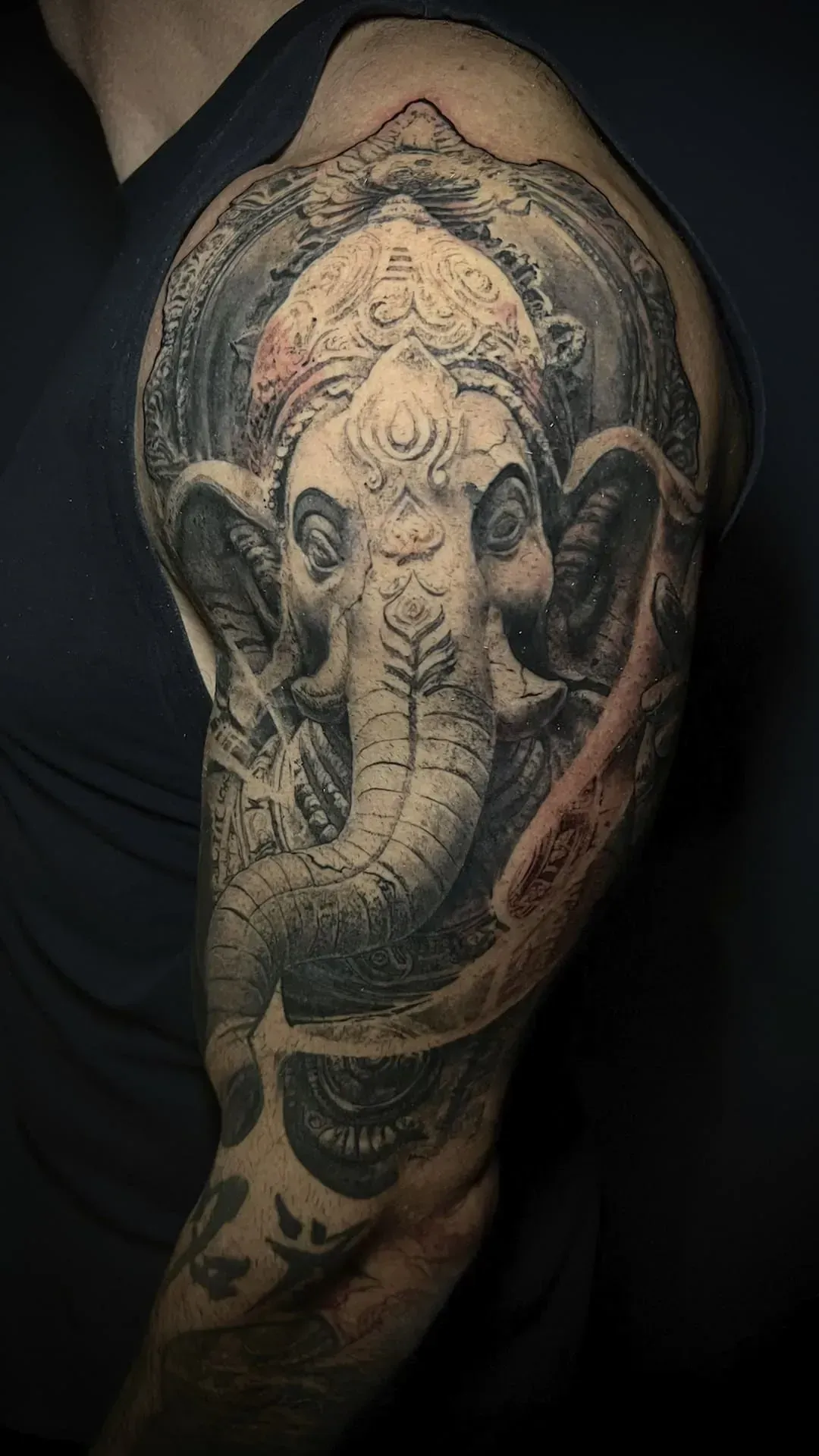 Tatuaje de Ganesha, la deidad hindú con cabeza de elefante, en la parte superior del brazo de una persona.
