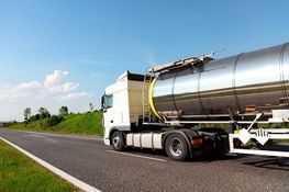 Un gran camión cisterna circula por una autopista.