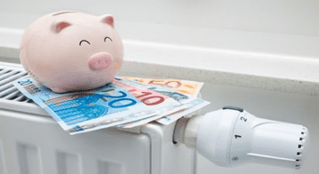Una alcancía con dinero está encima de un radiador.