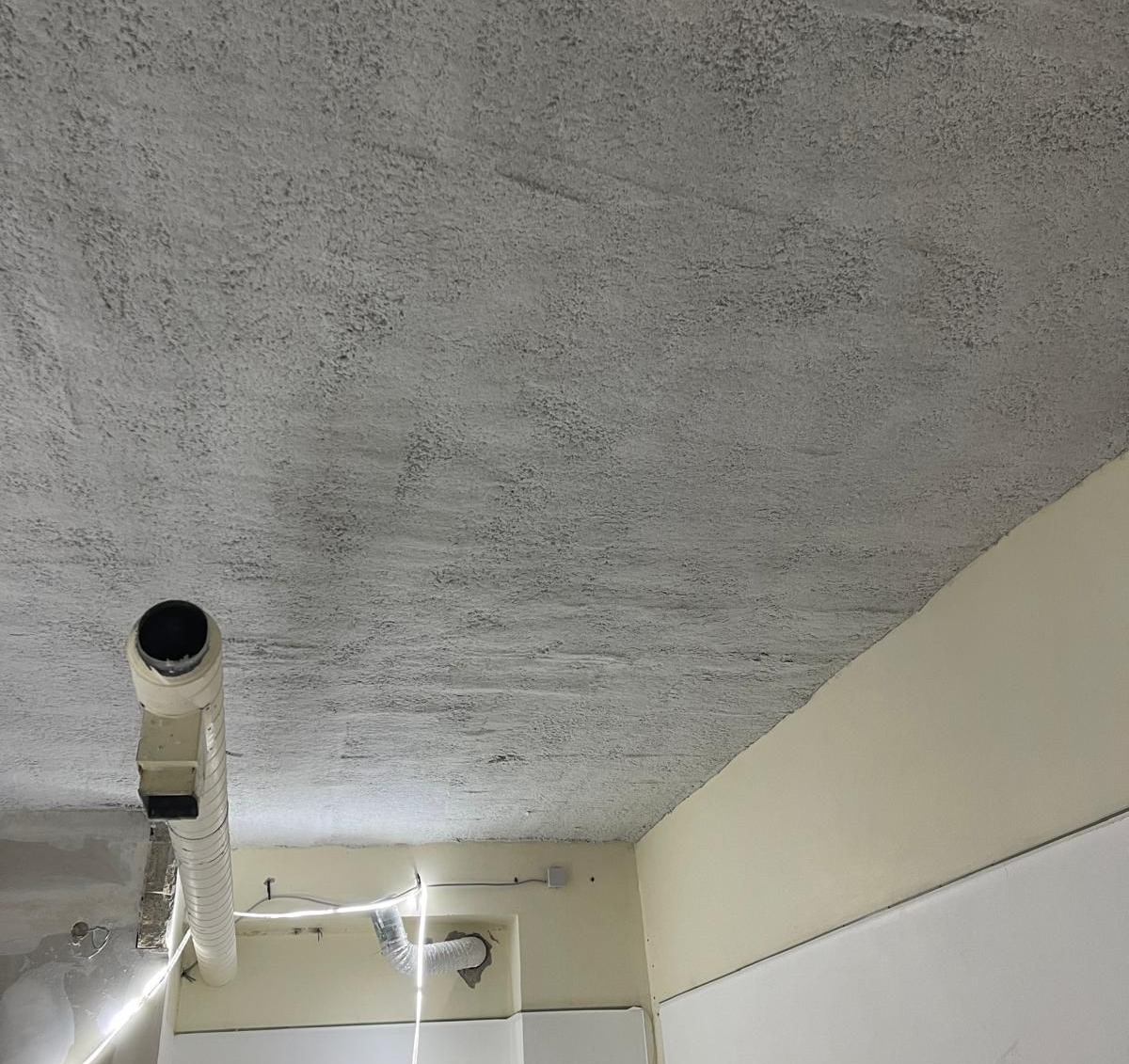 Plafond gris avec flocage coupe feu et tuyaux