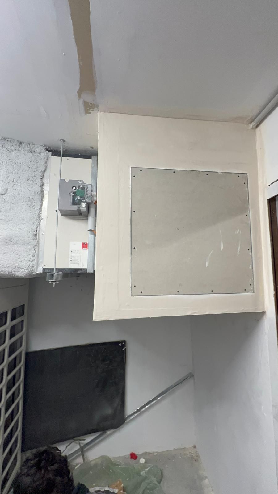 Réparation de cloisons sèches autour d'un panneau électrique à l'intérieur d'un bâtiment.