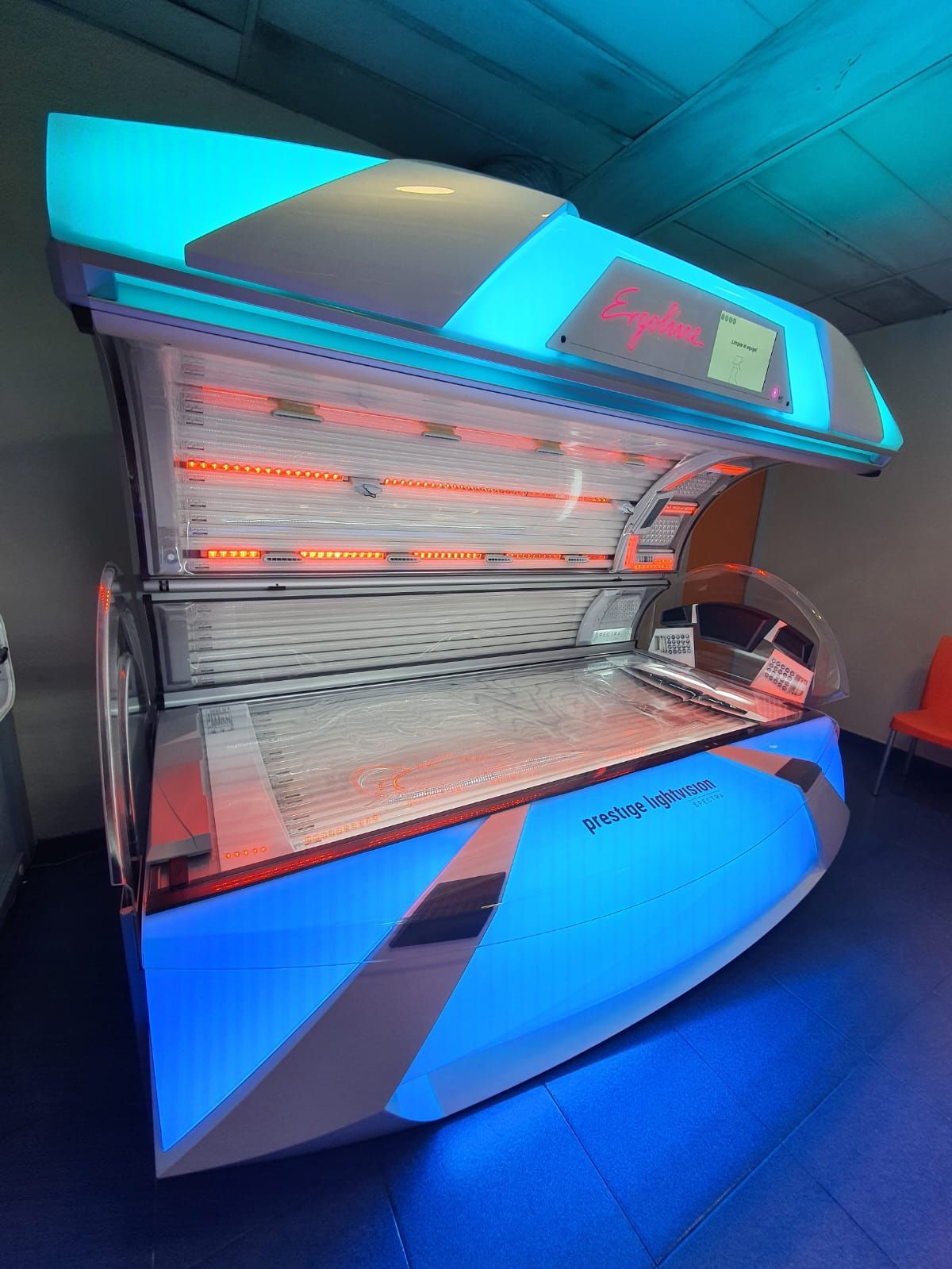 Una cama de bronceado con luces azules y naranjas.