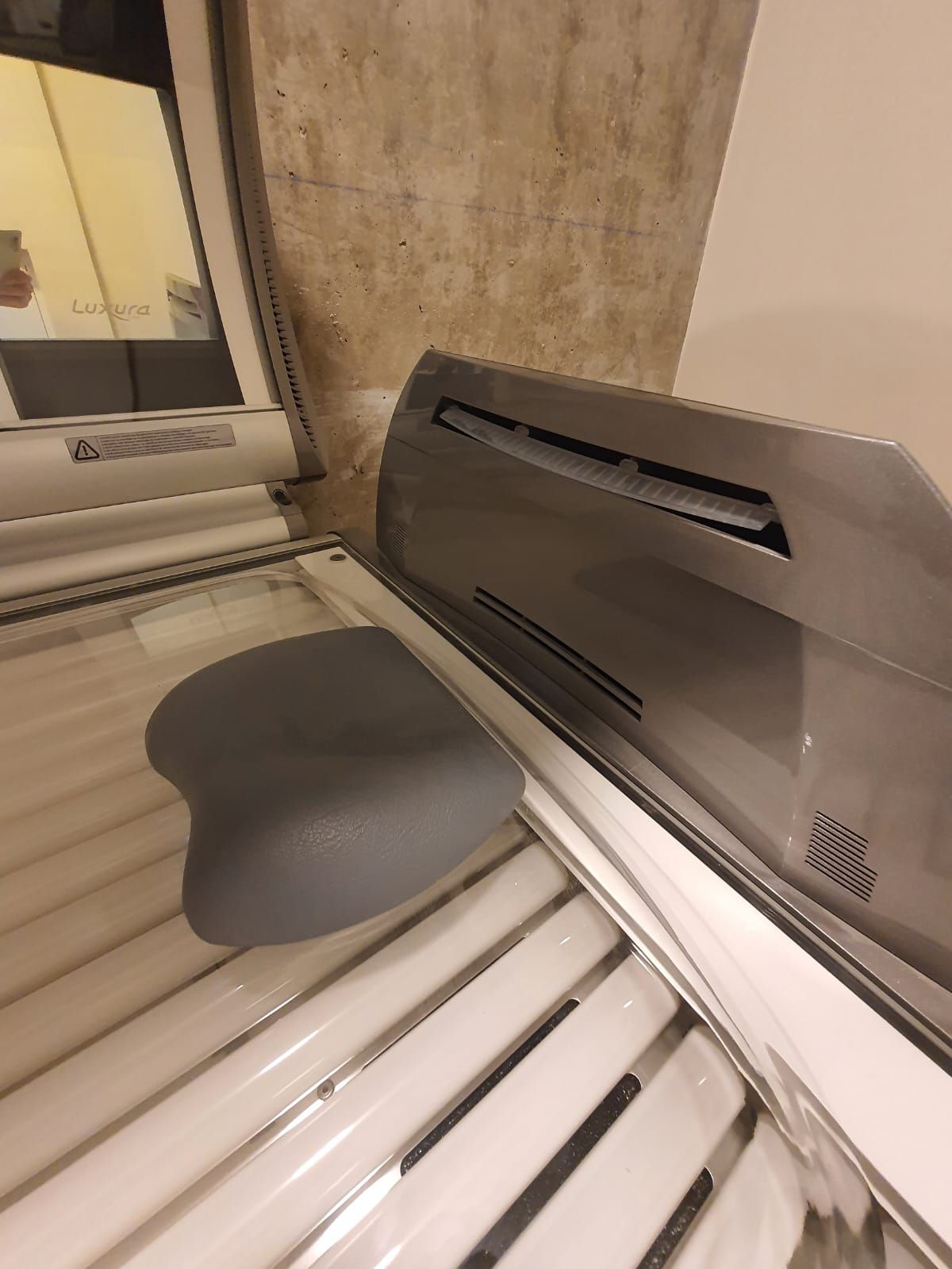 Interior de cama bronceadora con reposacabezas gris.