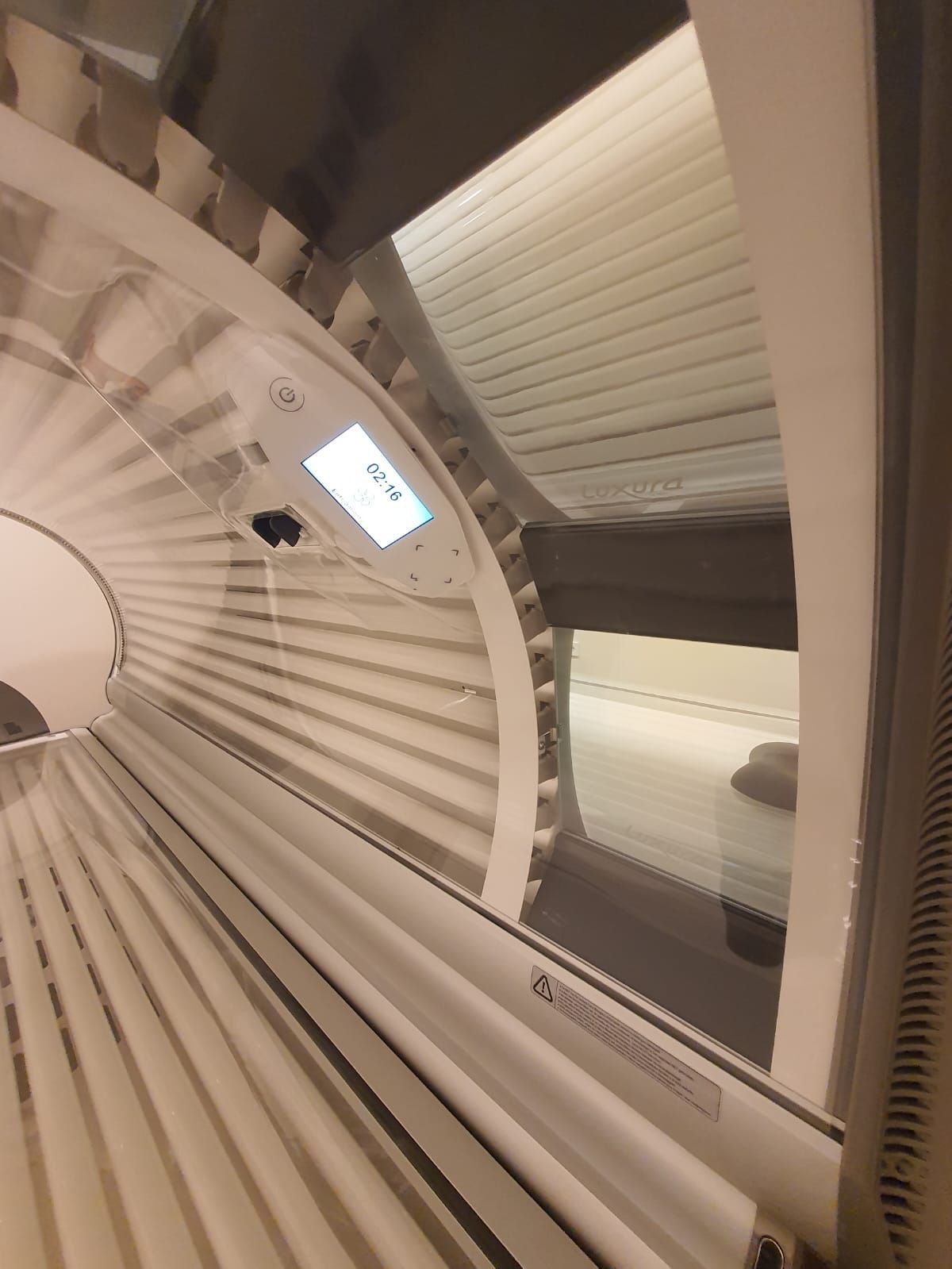 Interior de la cama de bronceado con luces fluorescentes. Se puede ver un temporizador digital en el interior.
