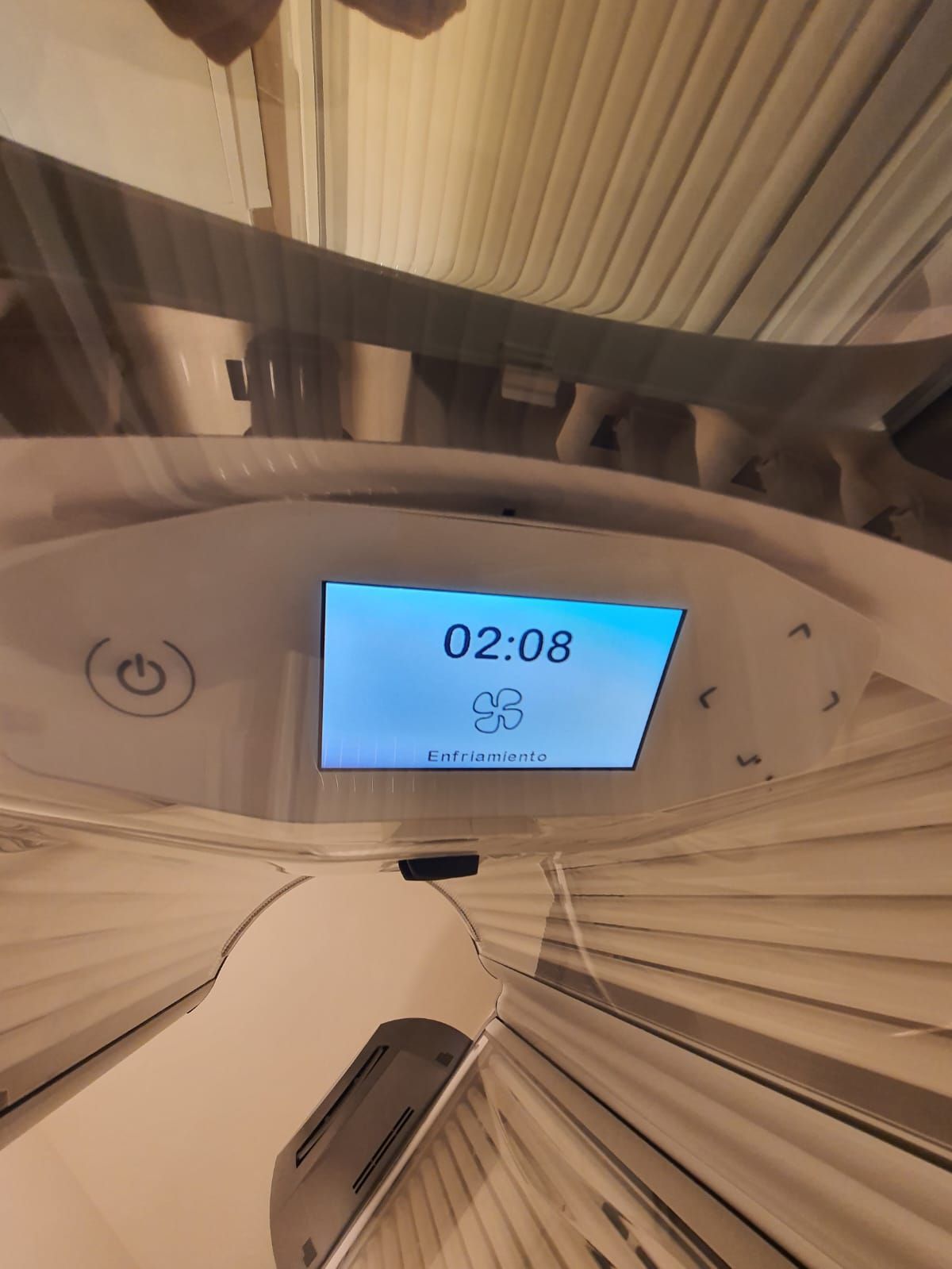 Panel de control de la cama bronceadora mostrando 02:08 en la pantalla; dentro de la cama bronceadora.