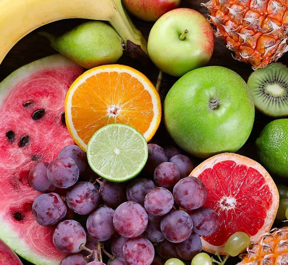 Un montón de frutas, incluyendo uvas, manzanas y sandía.