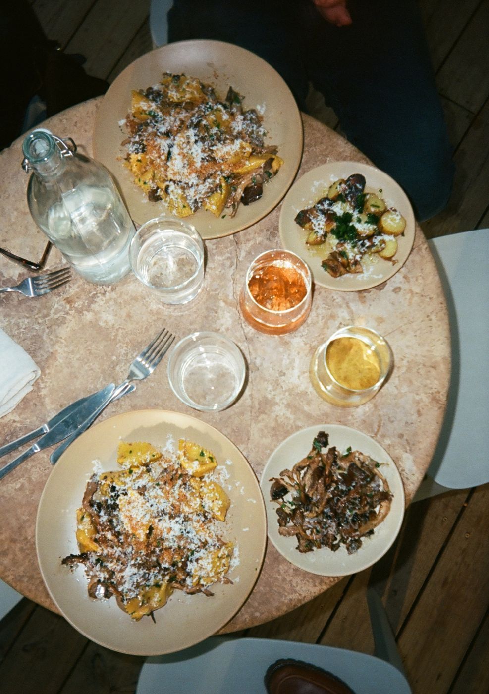 Pasta, small plates and wine on a restaurant table, seen from above