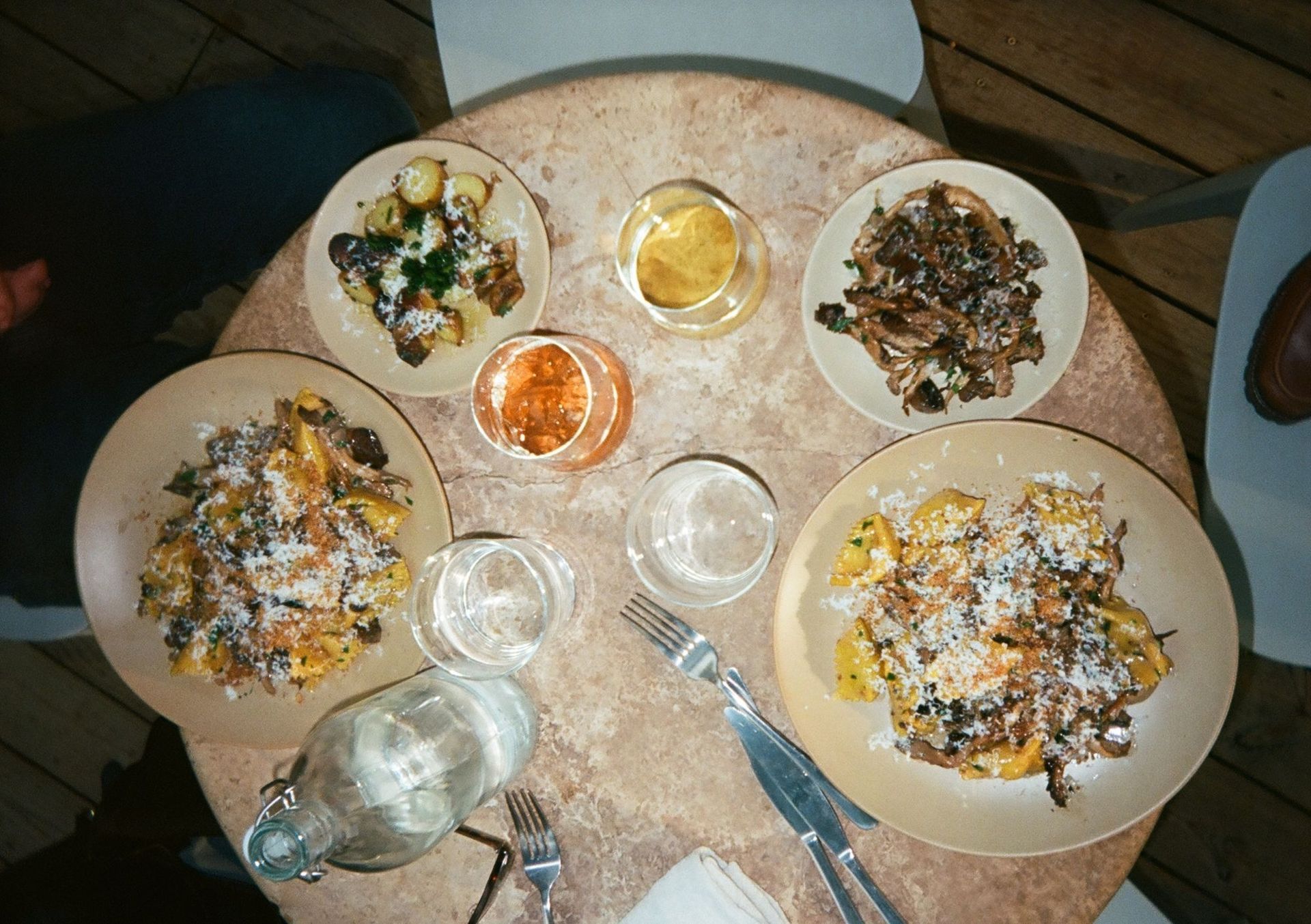 Pasta, small plates and wine on a restaurant table, seen from above