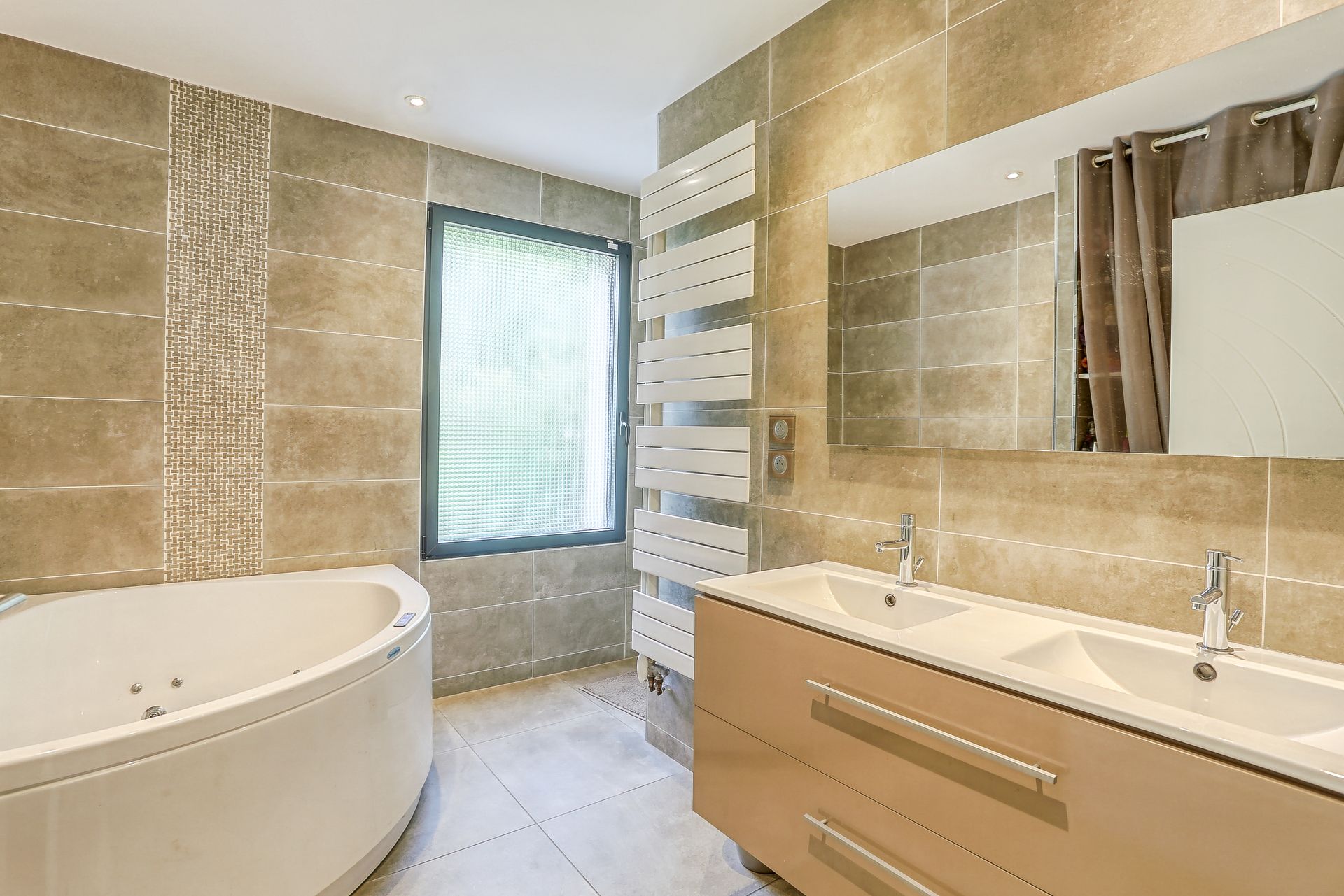 Salle de bains avec baignoire et sèche-serviette au mur