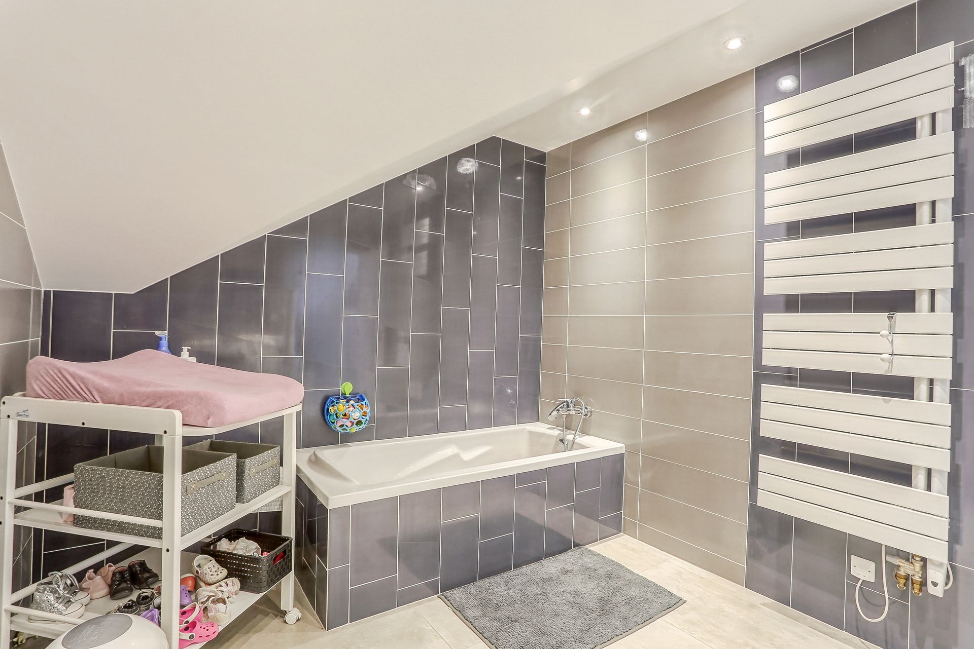 Salle de bains avec baignoire et revêtement carrelage