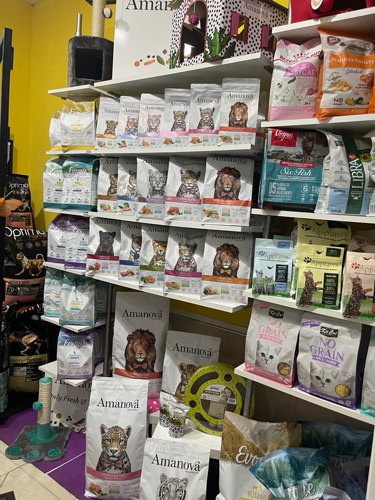 Un montón de bolsas de comida para perros están en un estante de una tienda.