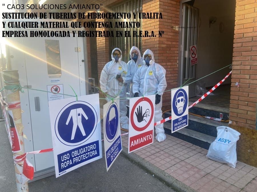 Un grupo de personas con trajes de protección están de pie frente a un edificio.