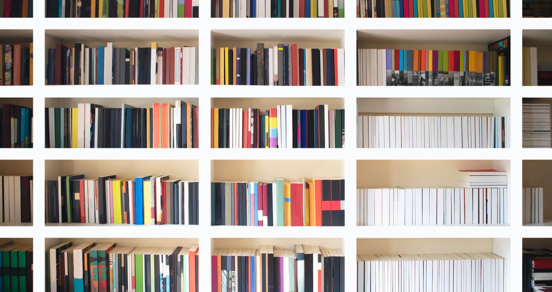 Des étagères blanches remplies de livres colorés bien rangés