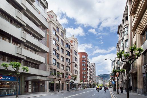 Una calle de la ciudad con muchos edificios y coches.