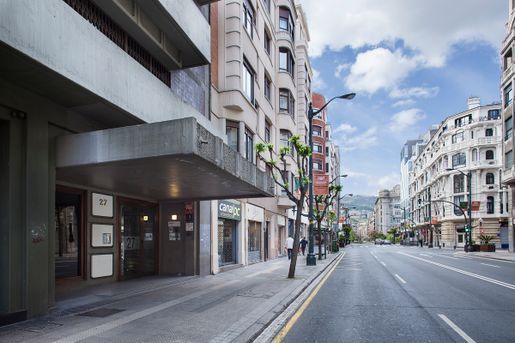 Una calle vacía de la ciudad con un gran edificio al fondo.