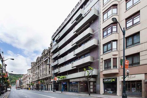Una calle de la ciudad con un gran edificio en el medio.