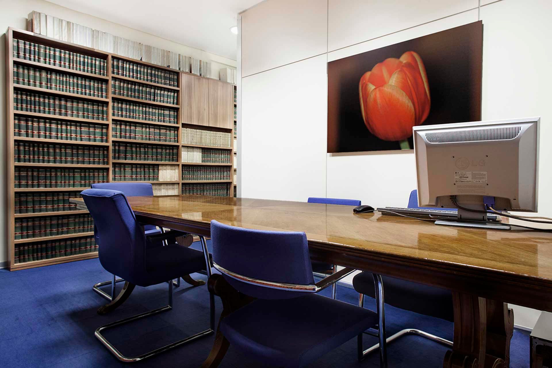 Una sala de conferencias con una mesa y sillas y una imagen de un tulipán en la pared.