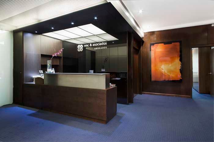 Un área de recepción en un edificio con una pintura en la pared.