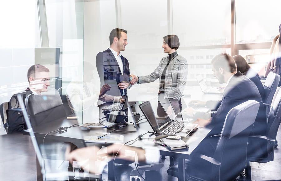 Un grupo de hombres de negocios se dan la mano en una sala de conferencias.