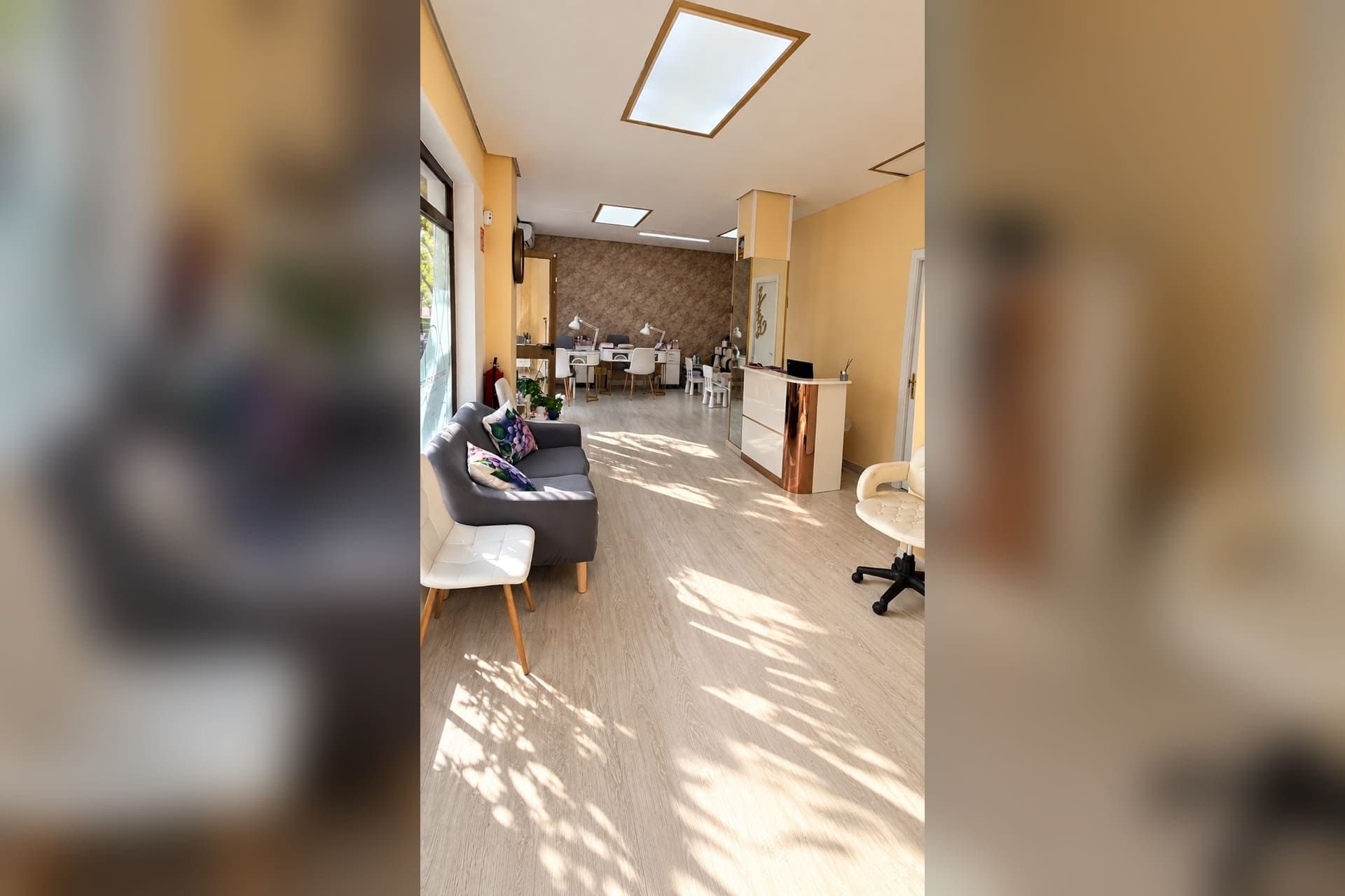 Luminoso salón con sofá, luz del sol sobre el suelo de madera y un comedor al fondo