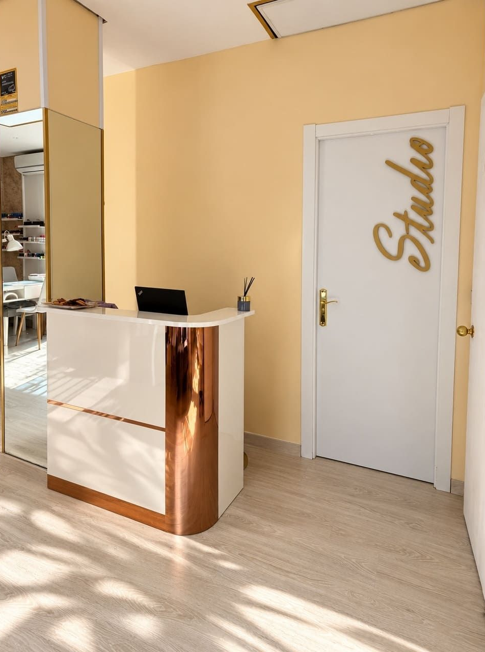 Mostrador de recepción moderno en un salón beige con una puerta blanca que dice «Sasha»