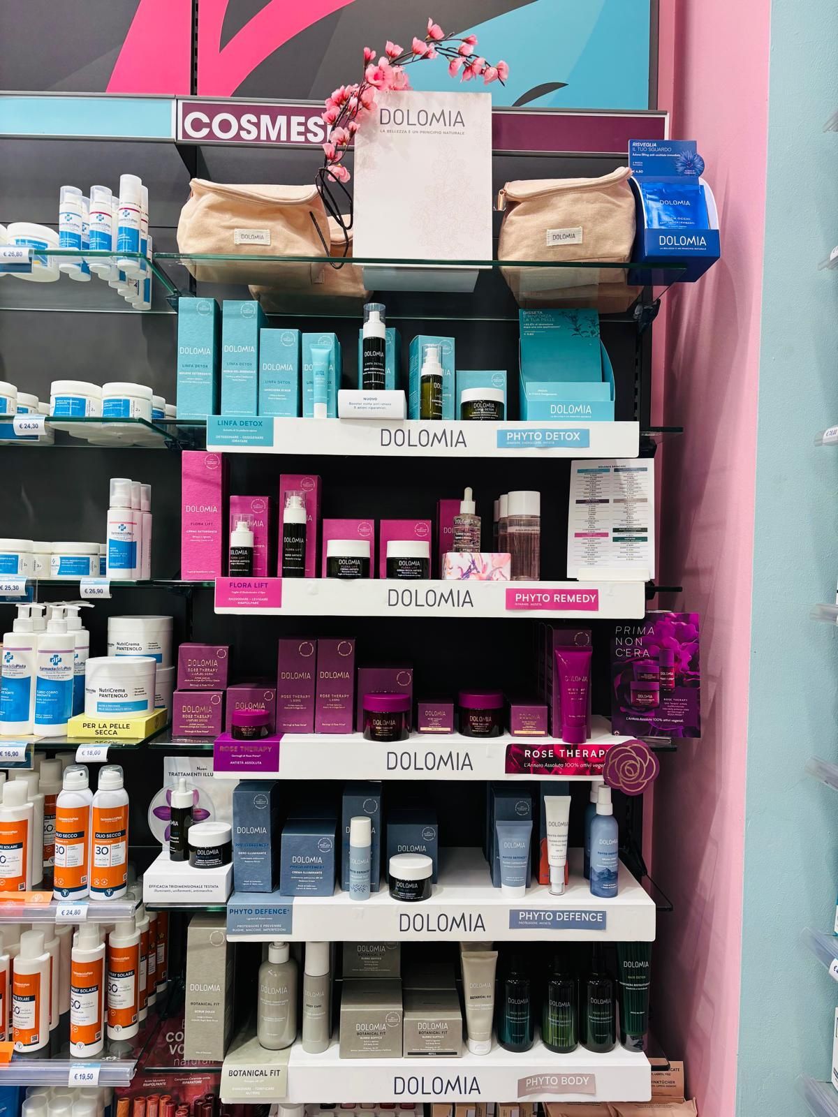 EsposizioneDolomia con cosmetici e prodotti per la cura della pelle su scaffali con confezioni rosa e blu