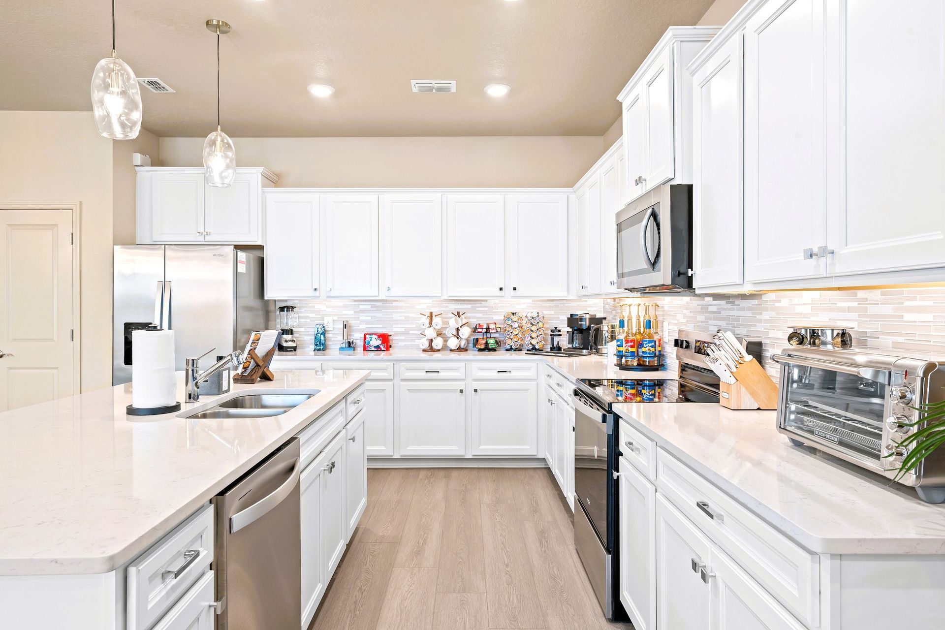 White kitchen with white cabinets, stainless steel appliances, and a large island.Windsor Cay Resort Community vacation home