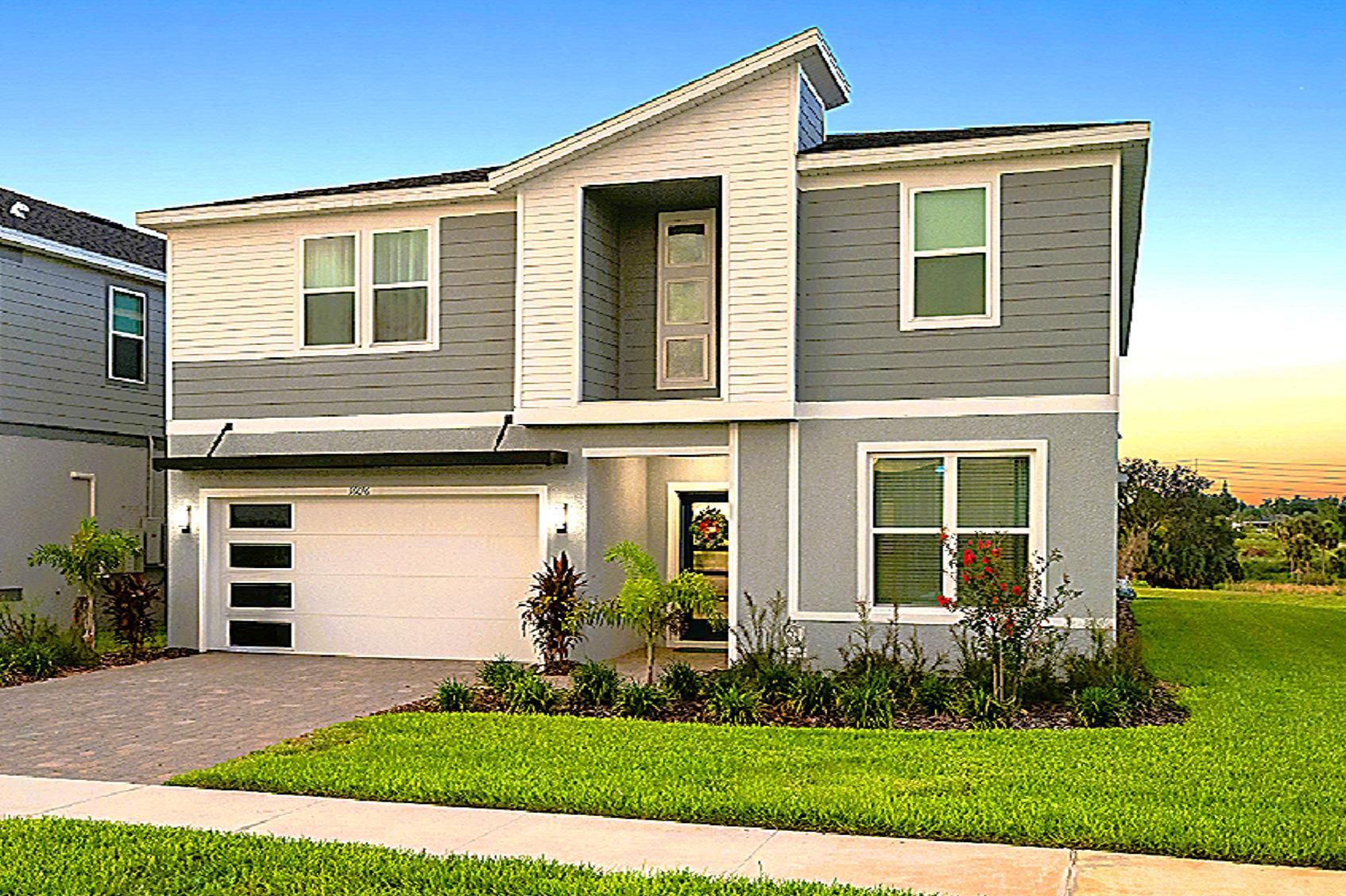 Two-story Clearwater Grande vacation home in Windsor Cay community with gray siding, white trim, and a garage door.