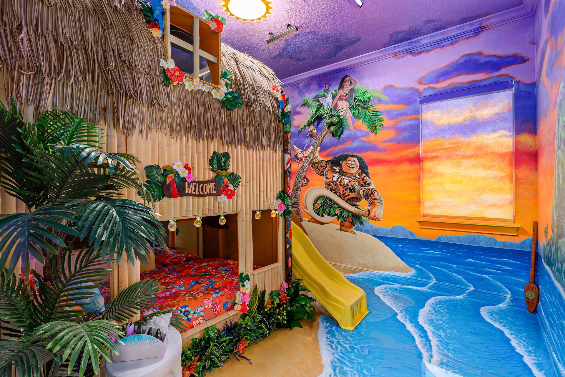 Tiki-themed bedroom with a thatched bunk bed, slide, and painted beach scene on the walls. Reunion Resort