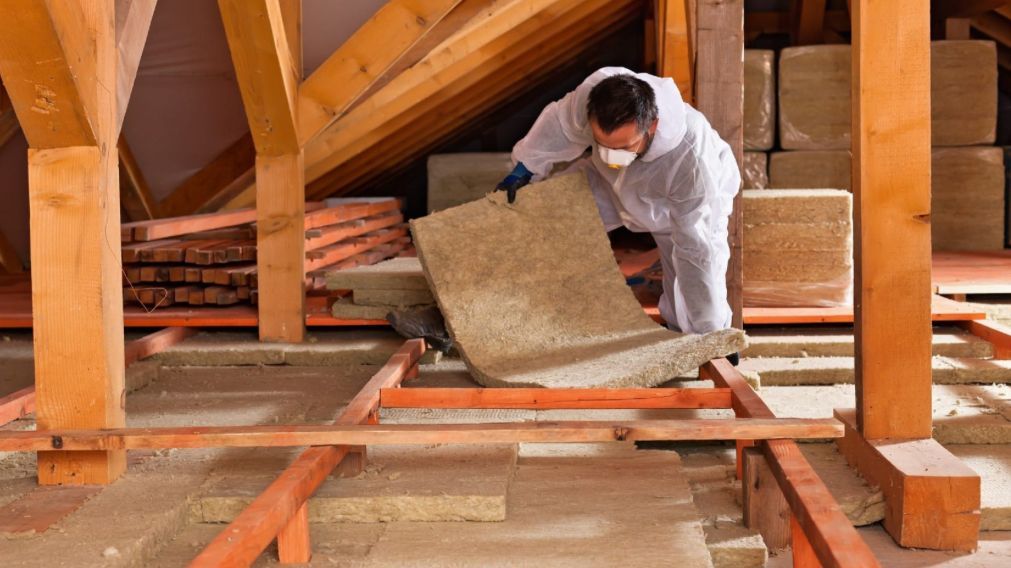 Un artisan réalise l'isolation de combles